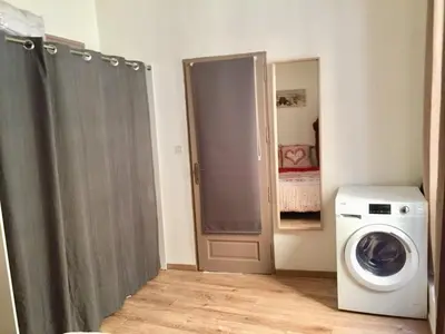 a room with a washing machine and a door at Appartement T2 Centre in Carpentras