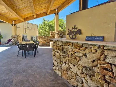 a patio with a stone wall and a table and chairs at Lou damisello - Villa moderne in Viens