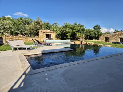 a pool of water with two chairs and a table at Lou damisello - Villa moderne in Viens