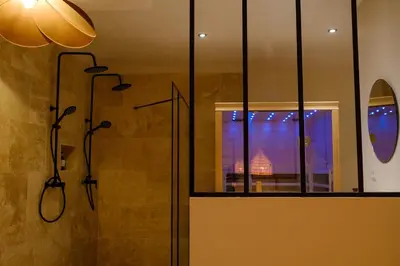 a bathroom with a shower with a window and a glass door at AMA, suite avec baignoire balnéo et sauna privé in Avignon
