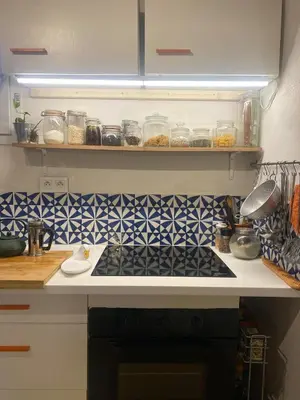 a kitchen with a counter and shelves with food at Gite la Muscadelle l Isle sur sorgue in LʼIsle-sur-la-Sorgue
