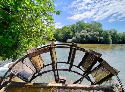 a bench sitting in the middle of a river at Gite la Muscadelle l Isle sur sorgue in LʼIsle-sur-la-Sorgue