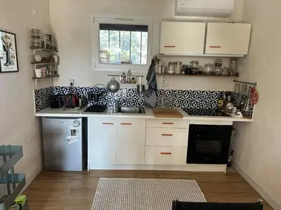 a kitchen with white cabinets and a stainless steel refrigerator at Gite la Muscadelle l Isle sur sorgue in LʼIsle-sur-la-Sorgue