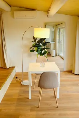 a table with a chair and a lamp in a room at L'Observateur in Aix-en-Provence
