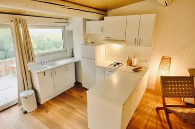 a kitchen with white cabinets and a sink and a window at L'Observateur in Aix-en-Provence