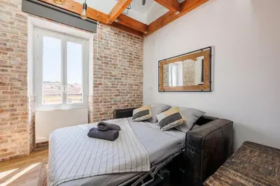 a bedroom with a bed in a brick wall at Duplex Factory II Hyper Centre in Salon-de-Provence