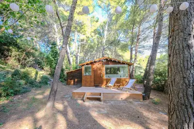 a cabin in the woods with two chairs and a tree at L'intimiste in Aix-en-Provence