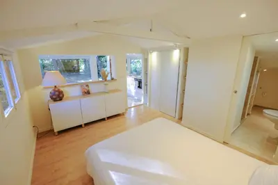 a white bedroom with a bed and a bathroom at L'intimiste in Aix-en-Provence