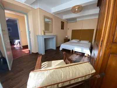 a bedroom with a bed and a couch in it at Le Rocan Roux in Aubignan