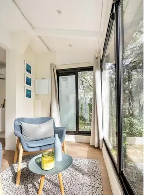 a living room with a blue chair and a table at Le Dandy in Aix-en-Provence