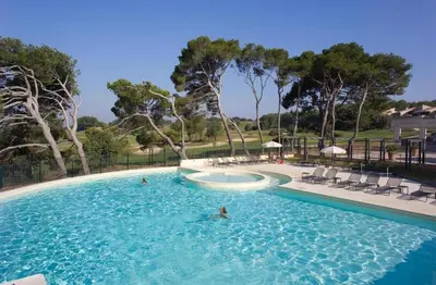 a swimming pool with two people in the water at Appartement Nature Golf de Saumane - Vue & Calme in Saumane-de-Vaucluse