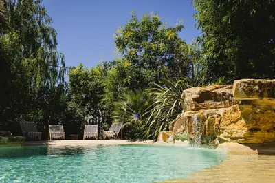 two chairs and a swimming pool in a garden at Grand Mas Provençal Luberon in Cavaillon