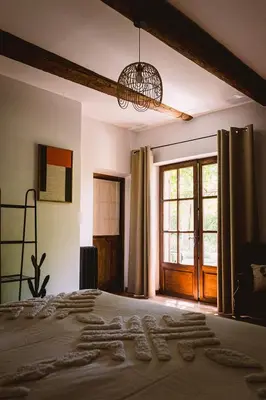 a bedroom with a bed and a large window at Grand Mas Provençal Luberon in Cavaillon
