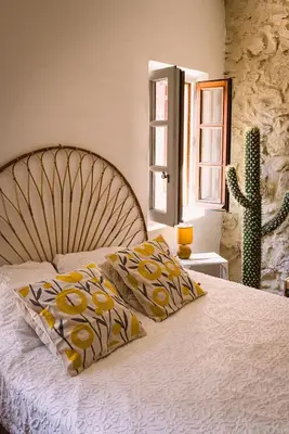 a bedroom with a bed with two pillows and a cactus at Grand Mas Provençal Luberon in Cavaillon