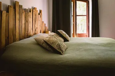 a bed with two pillows on it with a wooden headboard at Grand Mas Provençal Luberon in Cavaillon