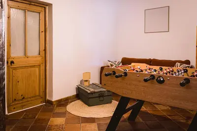 a room with a wooden foosball table in front of a couch at Grand Mas Provençal Luberon in Cavaillon