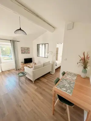 a living room with a table and a couch at Charmant appartement indépendant in Cavaillon