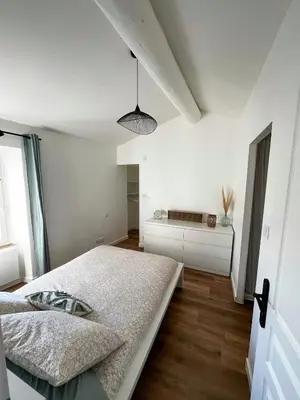 a white bedroom with a bed and a window at Charmant appartement indépendant in Cavaillon