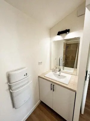 a white bathroom with a sink and a mirror at Charmant appartement indépendant in Cavaillon