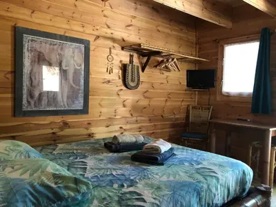 a bedroom with a bed in a log cabin at Cabane bambou in Apt
