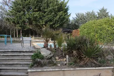 a garden with stairs and a tree and a bench at Cabane bambou in Apt