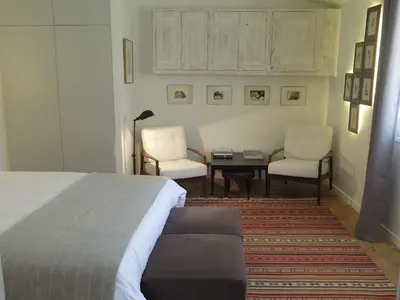 a bedroom with a bed and two chairs and a table at Appartement Quartier Mazarin in Aix-en-Provence