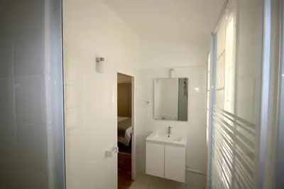 a white bathroom with a sink and a mirror at Appartement Quartier Mazarin in Aix-en-Provence