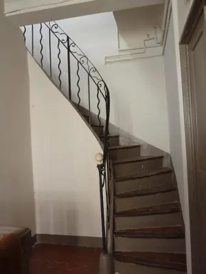 a staircase in a house with a metal railing at Appartement Quartier Mazarin in Aix-en-Provence