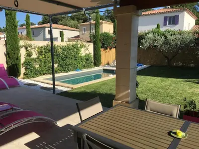 a patio with a table and chairs and a swimming pool at Mas Rémy-Villa in private residence in Saint-Rémy-de-Provence