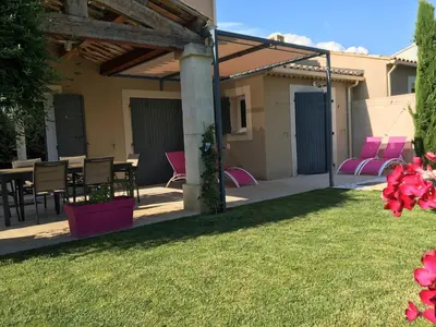 a patio with pink chairs and a table at Mas Rémy-Villa in private residence in Saint-Rémy-de-Provence