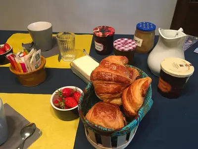 a table topped with a basket of croissants and strawberries at l'Estagnol in Ansouis