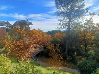 a house in the middle of a field with trees at Au sommet des Ocres et des Bois - Maison T3 & Parking in Roussillon
