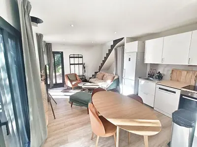 a kitchen and living room with a wooden table in a room at Au sommet des Ocres et des Bois - Maison T3 & Parking in Roussillon