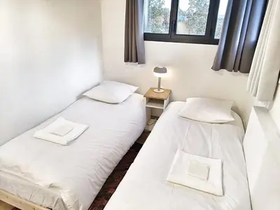 two twin beds in a room with a window at Au sommet des Ocres et des Bois - Maison T3 & Parking in Roussillon