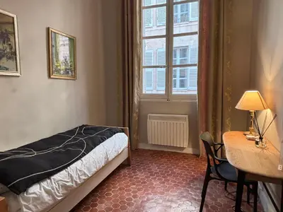 a bedroom with a bed and a desk and a window at L Appart Aixois in Aix-en-Provence