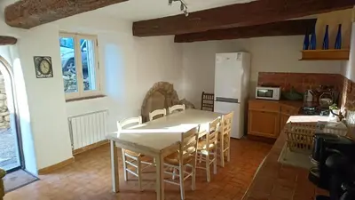 a kitchen with a table and chairs in a room at Grande maison de village - solarium et terrasse in Saint-Martin-de-Castillon