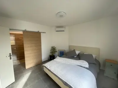 a bedroom with a bed and a sliding door at l'Esquirou in Malemort-du-Comtat