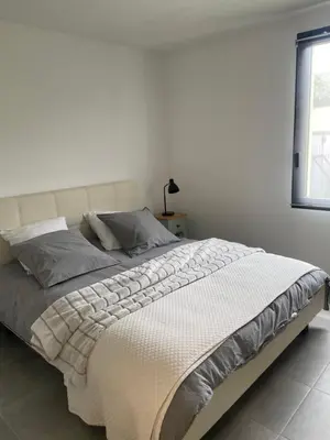 a white bedroom with a large bed with a white headboard at l'Esquirou in Malemort-du-Comtat