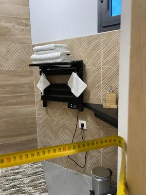a yellow measuring tape on a bathroom wall with towels at l'Esquirou in Malemort-du-Comtat