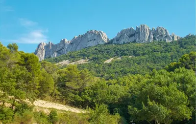 a mountain with trees and rocks in the background at Lovely Home In Carpentras With Wifi in Carpentras