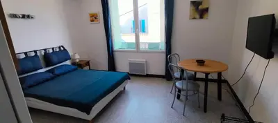 a bedroom with a bed and a table and a window at GitesLuberon 1 studio in Charleval
