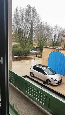 a car parked in a parking lot next to a garage at GitesLuberon 1 studio in Charleval