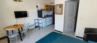a room with a table and a kitchen with a table and chairs at GitesLuberon 1 studio in Charleval