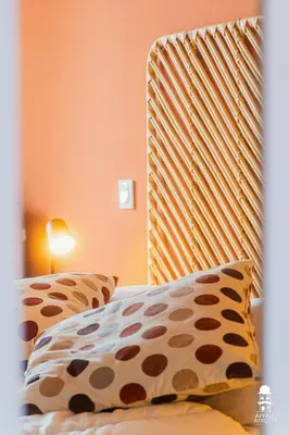 a bed with a wooden headboard and two pillows at Le Cézanne in Aix-en-Provence