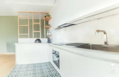 a kitchen with white counters and a sink and a sink at Le Cézanne in Aix-en-Provence