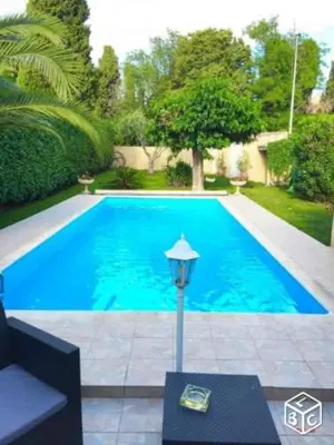 a blue swimming pool with a light next to it at Appartement indépendant dans une villa in Miramas