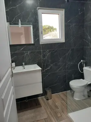 a bathroom with a toilet and a sink and a window at Appartement indépendant dans une villa in Miramas