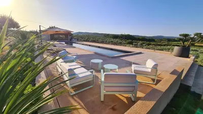 a swimming pool with chairs and a table and a swimming pool at Domaine des Hauts de Riganel in La Bastide-des-Jourdans