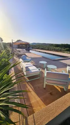 a pool with a row of white benches next to it at Domaine des Hauts de Riganel in La Bastide-des-Jourdans