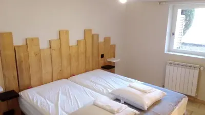 a bedroom with a large wooden headboard with two towels at Domaine des Hauts de Riganel in La Bastide-des-Jourdans